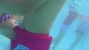 Good friend couple flirting in the pool, girlfriend squeezing her boyfriend over her swimsuit