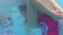 Good friend couple flirting in the pool, girlfriend squeezing her boyfriend over her swimsuit